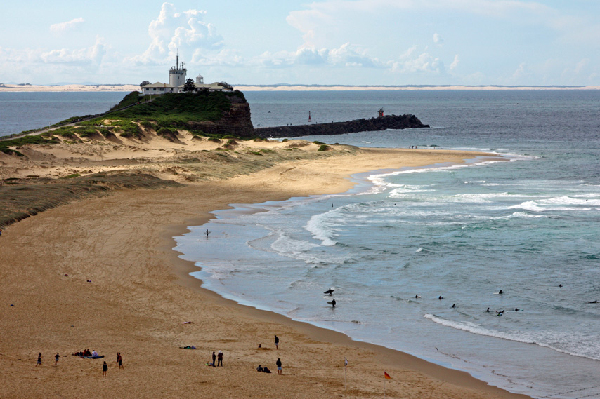 Iconic view of Nobby's Head Lighthouse with the break wall extending into the ocean.