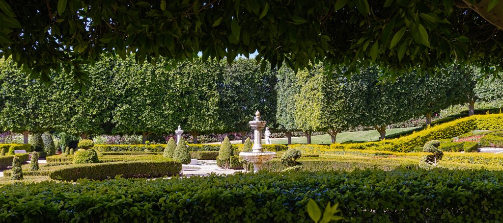 Beautifully manicured grounds, featuring a tiered water fountain hedged in a serene setting.