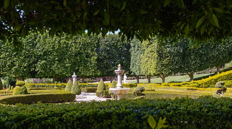 Beautifully manicured grounds, featuring a tiered water fountain hedged in a serene setting.