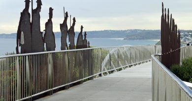 Newcastle Memorial Walk bridge above the ocean cliffs. Steel soldier silhouettes line the walkway, engraved with the names of soldiers from the region who enlisted in WW1.